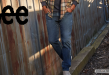 man wearing Lee blue jeans walking along a railroad tie