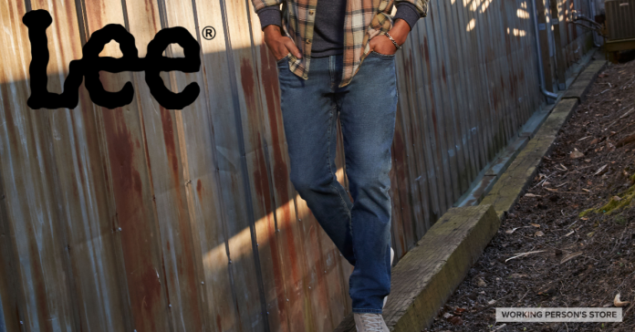 man wearing Lee blue jeans walking along a railroad tie