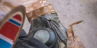 Ditch the Duct Tape: Time for a Workwear Overhaul Black boots with brown duct tape